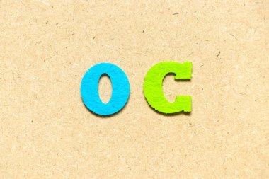 Ahşap zemin üzerinde renk bezi alfabesi harfi OC (fırsat maliyetinin kısaltılması veya orijinal içerik, karakter)