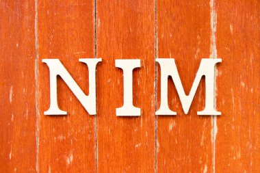 Alfabe harfi NIM (Net faiz marjının kısaltması) eski kırmızı ahşap kaplama arka planında