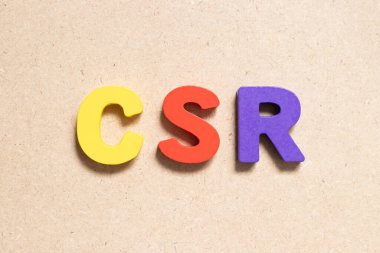 Ahşap zemin üzerinde kelime CSR (kurumsal sosyal sorumluluğun kısaltması) renk alfabesi harfi