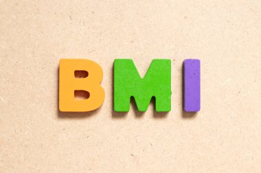 Color alphabet letter in word BMI (abbreviation of body mass index) on wood background