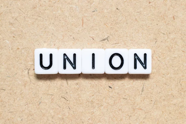 Ahşap zemin üzerinde kelime sendikası olan beyaz karo alfabe harfi