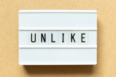 Lightbox with word unlike on wood background