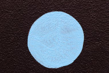 Grunge blue color painting as round shape on brown concrete wall textured background with copy space