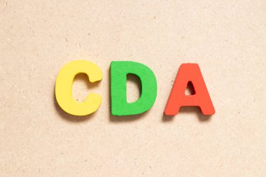 Ahşap arkaplan üzerindeki renk alfabesi harfi CDA (Gizli ifşaat anlaşmasının kısaltması)