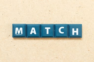 Ahşap arkaplanda kelime eşleşmesi içeren döşeme alfabesi harfi