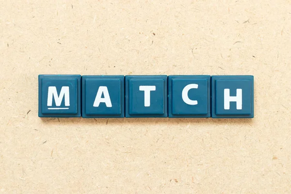 Ahşap arkaplanda kelime eşleşmesi içeren döşeme alfabesi harfi