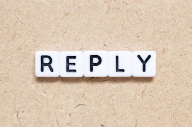 Tahta zemin üzerinde kelime yanıtı olan beyaz kiremit alfabesi harfi