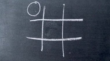 El ele tutuşun beyaz tebeşirle çizim tahtası arka planında tik tac toe oyunu ve O galibiyet tarafı.