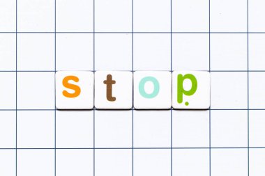Colorful tile letter in word stop on white grid background