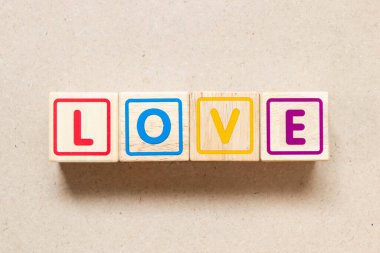 Color letter block in word love on wood background