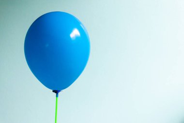 Blue balloon on blue concrete wall background with copy space