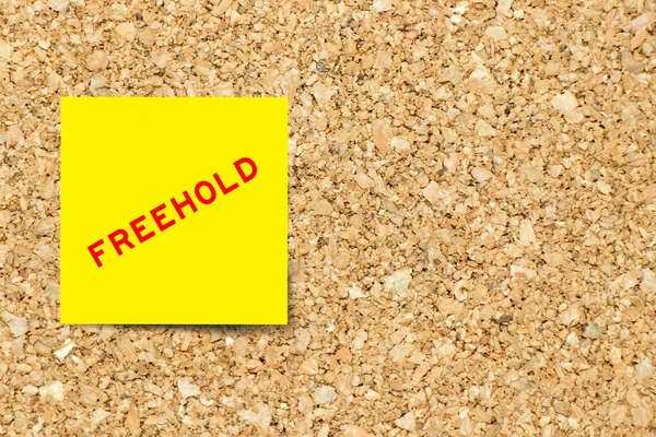 Yellow Note Paper Word Freehold Cork Board Background Copy Space — Φωτογραφία Αρχείου