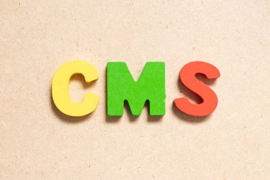 Ahşap zemin üzerinde kelime CMS (İçerik yönetim sisteminin kısaltması) renk alfabesi harfi