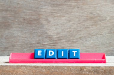 Tile letter on red rack in word edit on wood background