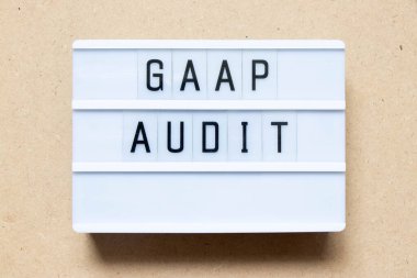 Lightbox with word GAAP (Abbreviation of Generally accepted accounting principles) audit on wood background