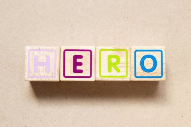Color letter block in word hero on wood background