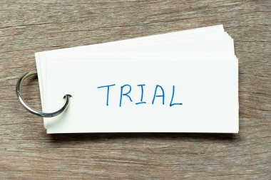 Flash card with handwriting word trial on wood background