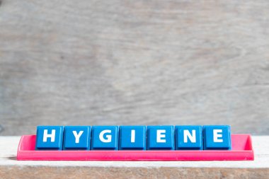 Tile alphabet letter with word hygiene in red color rack on wood background