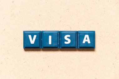 Tile letter in english word visa on wood background