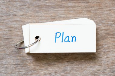 Flash card with handwriting in word plan on wood background