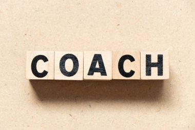 Ahşap arka planda kelime koçu alfabe mektup bloğu