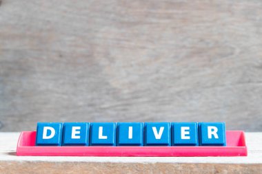 Tahta zemin üzerinde kırmızı renkli raflarda kelime dağarcığı olan döşeme alfabesi harfi