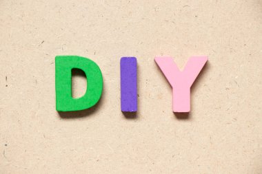 Ahşap zemin üzerinde kelime DIY (kendin yap kısaltması) renk alfabesi harfi
