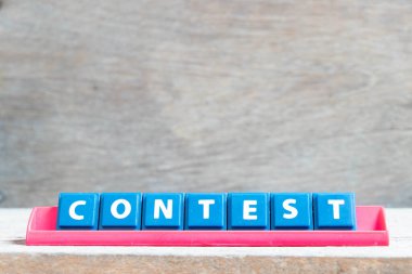 Tahta zemin üzerinde kırmızı renk rafı ile kelime yarışması ile harf döşeme