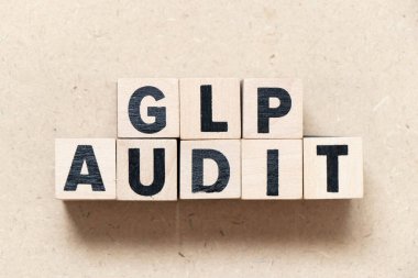 Kelime GLP ile alfabe harf bloğu (İyi laboratuvar uygulamasının kısaltması) ahşap arkaplan denetimi