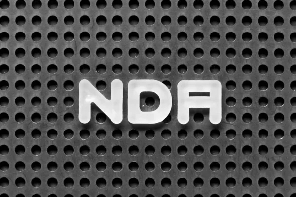 Siyah tahta zemin üzerinde NDA (NDA 'nın kısaltması) ile beyaz alfabe harfi