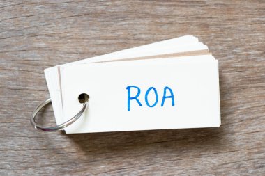 Tahta zemin üzerinde Kelime ROA (Varlıkların Dönüşü kısaltması) ile el yazısı ile Flash kart