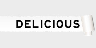 Yırtılmış gri kağıt arka planda yırtık bölümün altında lezzetli kelimeler var.