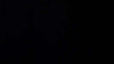 İnsan eli siyah arka planda izole edilmiş tıbbi koruyucu maske takıyor.