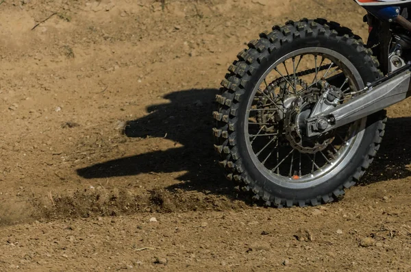 오토바이의 바퀴는 트랙을 속도로 달리고 먼지는 밑에서 날아간다 — 스톡 사진