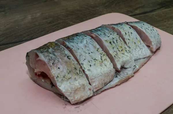 まな板の上で鯉の魚をステーキに切る — ストック写真