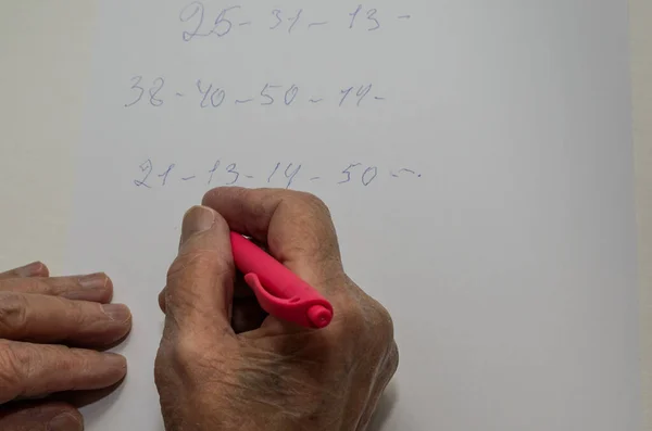 Die Hand Einer Älteren Frau Schreibt Mit Einem Stift Zahlen — Stockfoto