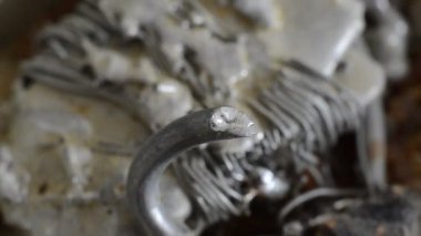 Usta lehimleme demiriyle tenekeyi eritiyor.