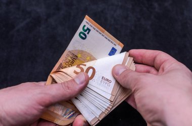 A man counts money - euro banknotes with a face value of 50 euros