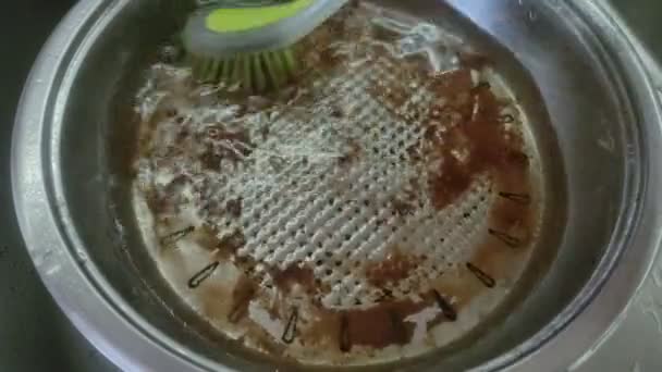 洗碗机用刷子在洗脸盆里洗一个肮脏的油腻油锅 — 图库视频影像