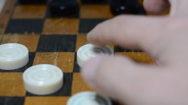 İnsanlar satranç tahtasında dama oynarlar.