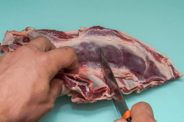 Hentes Bárányhúst Vág Késsel Vágódeszkán — Stock Fotó