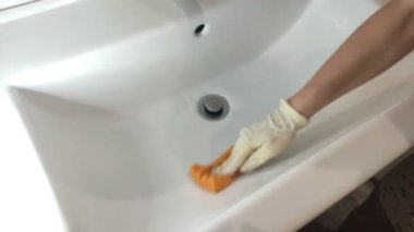 Hizmetçinin eli banyodaki lavaboyu ev kimyasallarıyla yıkadı.