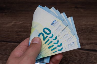Elinde 20 avroluk banknot tutan adam.