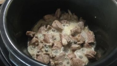 The cook fries pieces of lamb meat in a pan