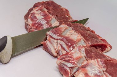 Butcher cuts lamb fillet with a knife on a cutting board