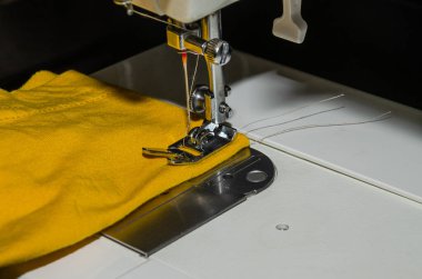 Tailor sews fabric for clothing on a sewing machine in a tailor shop