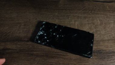 Servis merkezindeki usta akıllı telefondaki kırık camları değiştiriyor.