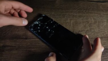 Servis merkezindeki usta akıllı telefondaki kırık camları değiştiriyor.