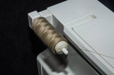 Tailor sews fabric for clothing on a sewing machine in a tailor shop