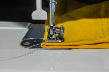 Tailor sews fabric for clothing on a sewing machine in a tailor shop
